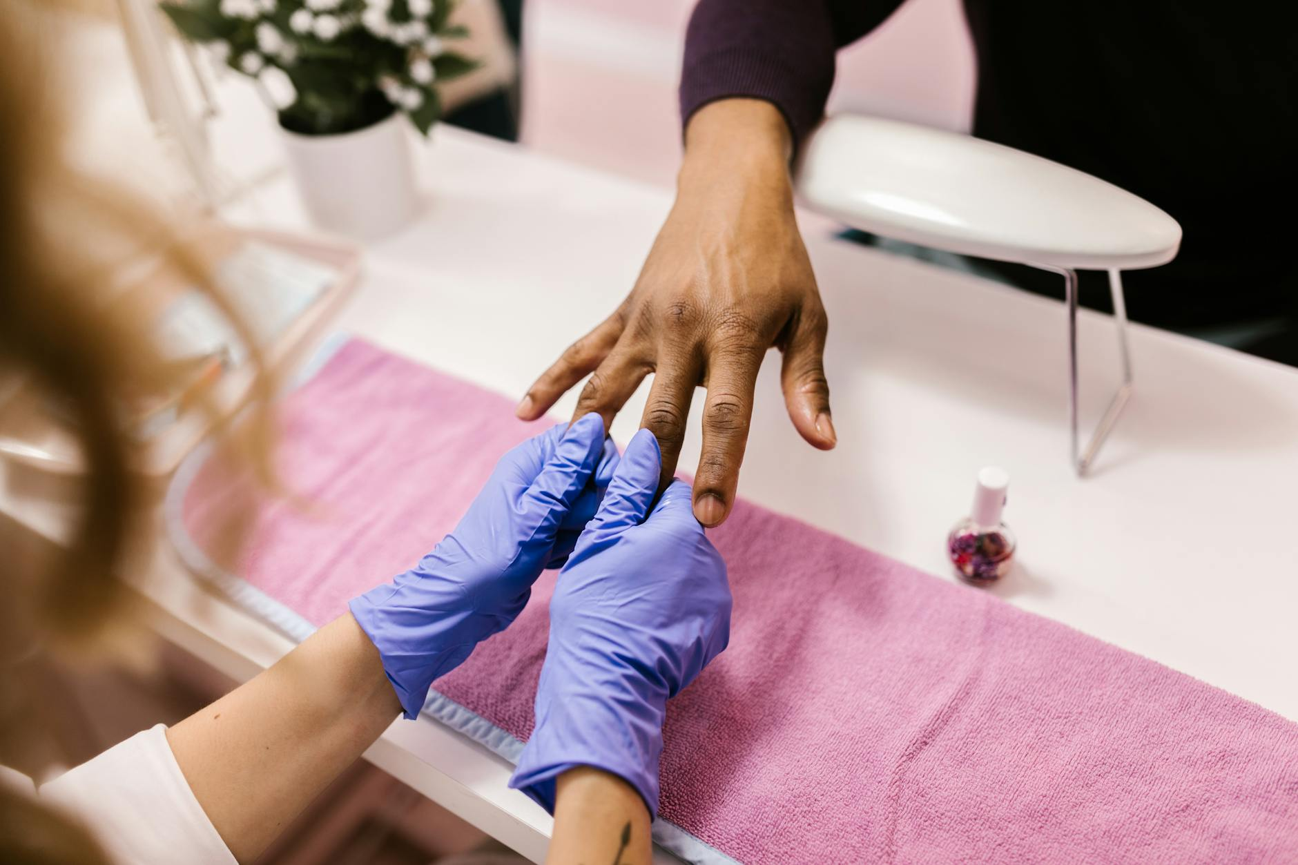 hands wearing blue latex gloves holding the person s hand